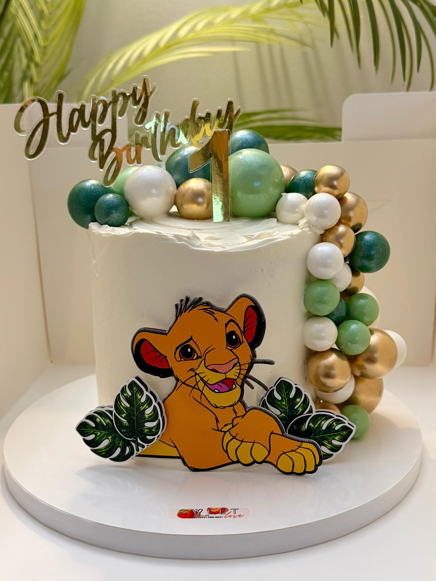 Custom Lion King Simba cake topper for 1st birthday with gold 'Happy Birthday' acrylic and balloon garland