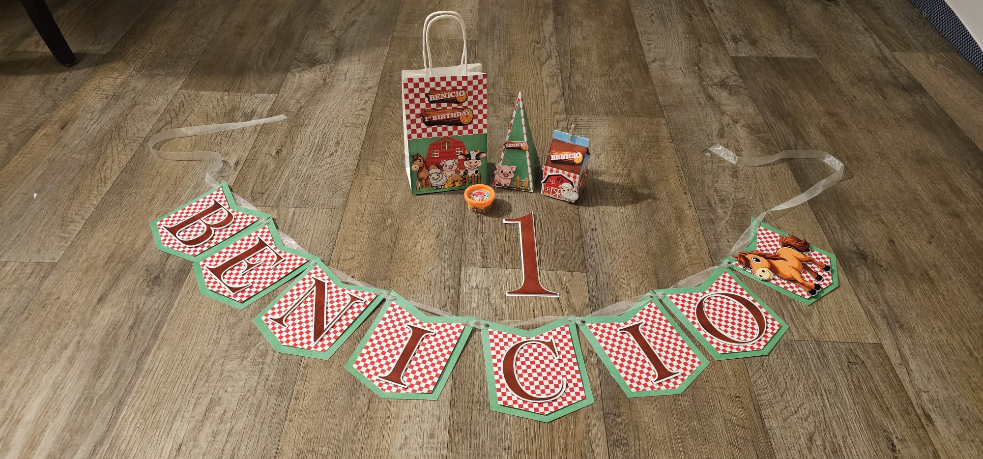 Custom farm-theme name banner with red gingham letters and matching favor set for Benicio's 1st birthday